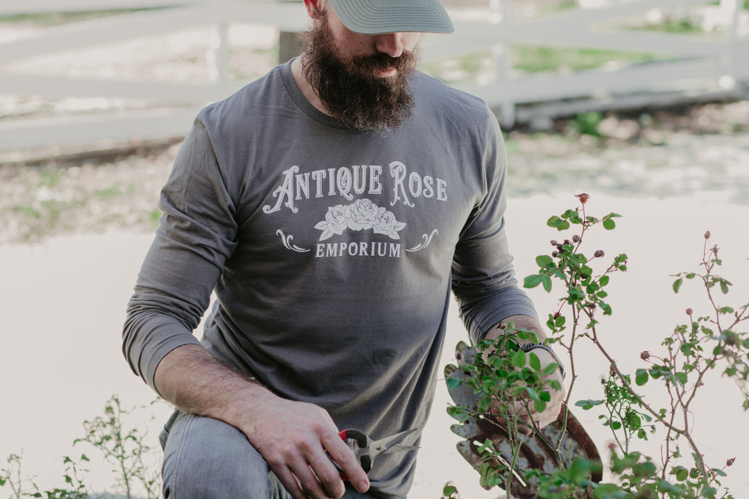 man in garden wearing gray long sleeve logo shirt