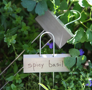 two metal plant markers leaning against greenery